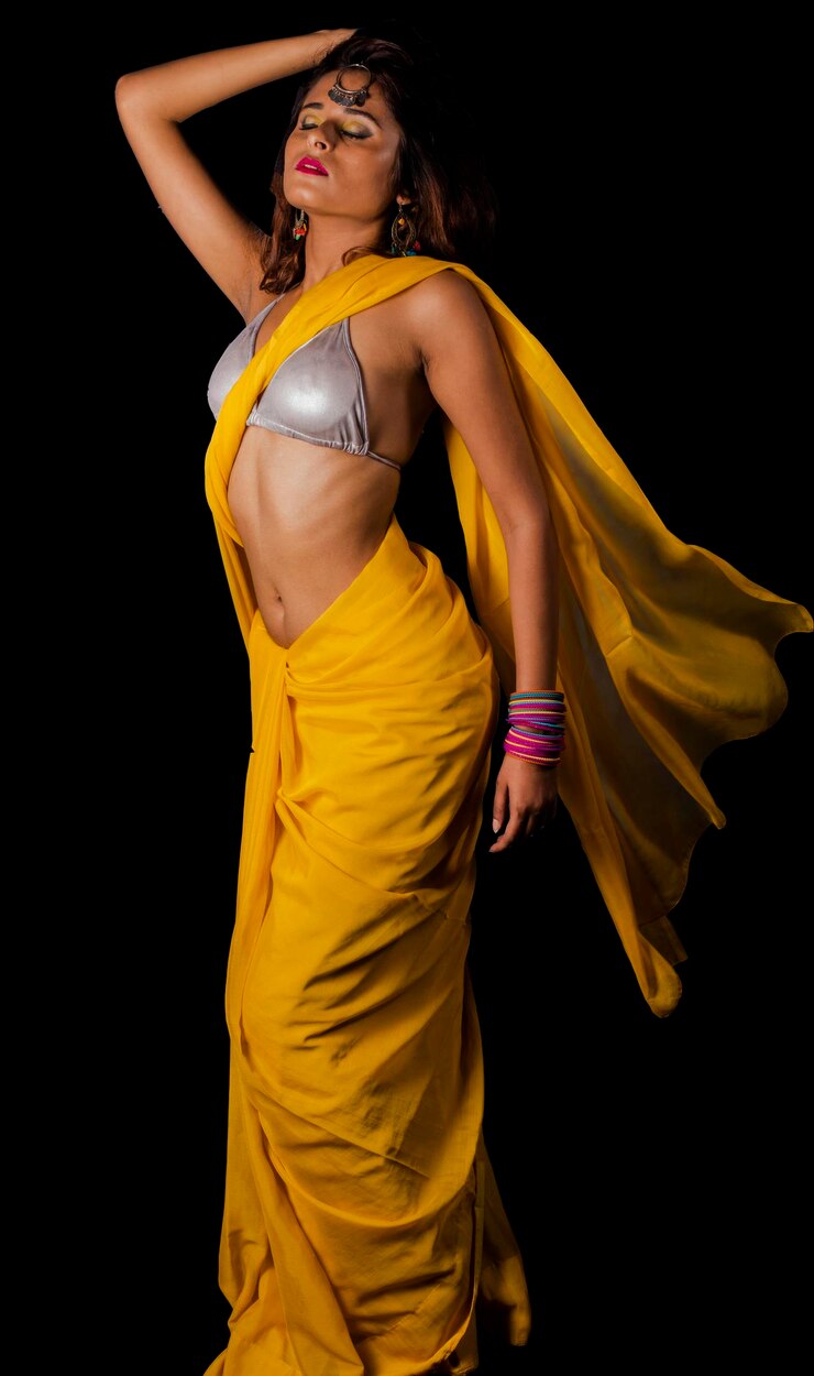woman-yellow-sari-standing-against-black-background_1048944-25692691